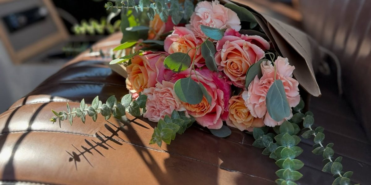 A hand-tied bouquet of peach roses and eucalyptus riding on the seat of Growe&rsquo;s 1959 Apache flower truck