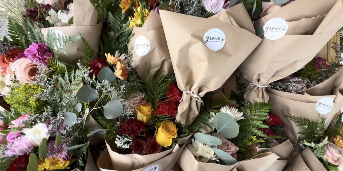 A table of hand-tied Growe bouquets wrapped in kraft paper, ready for delivery